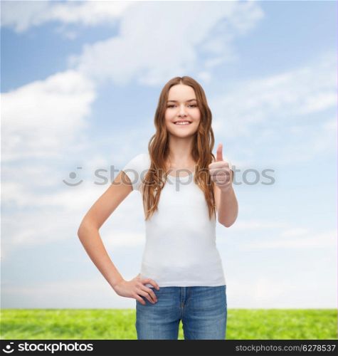 t-shirt design concept - smiling teenager in blank white t-shirt showing thumbs up