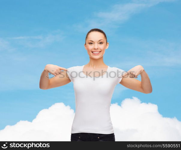 t-shirt design concept - smiling woman in blank white t-shirt pointing at herself