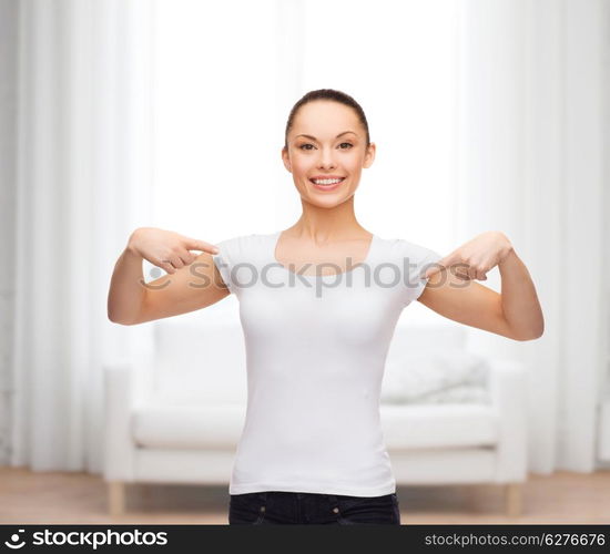 t-shirt design concept - smiling woman in blank white t-shirt pointing at herself