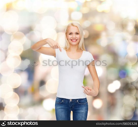 t-shirt design concept - smiling young woman pointing finger to blank white t-shirt
