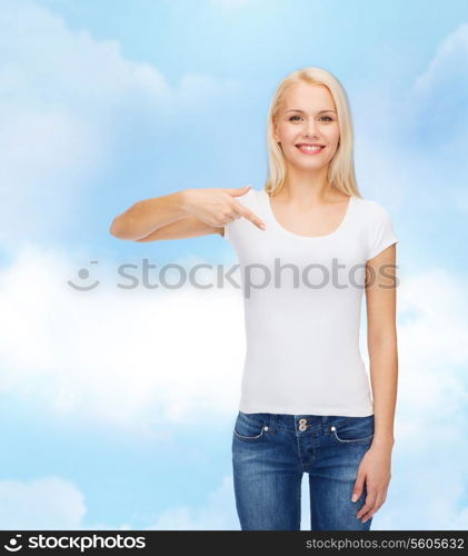 t-shirt design concept - smiling young woman pointing finger to blank white t-shirt