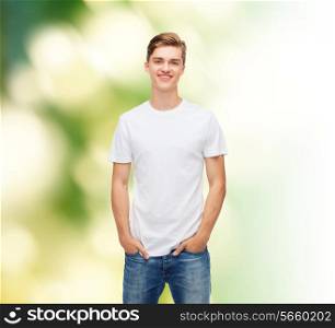 t-shirt design, ecology and advertising people concept - smiling young man in blank white t-shirt over green background