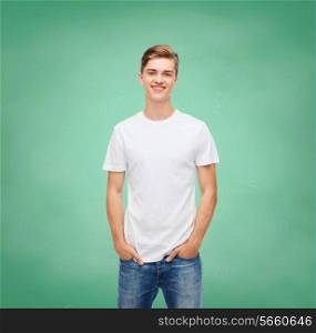 t-shirt design, education, school, advertising and people concept - smiling young man in blank white t-shirt over green board background
