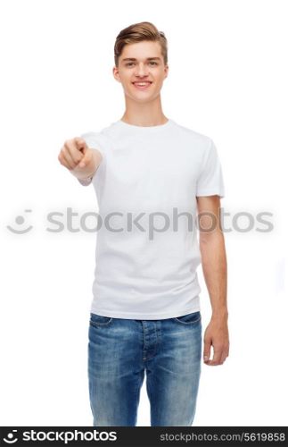 t-shirt design, gesture and people concept - smiling young man in blank white t-shirt pointing at you