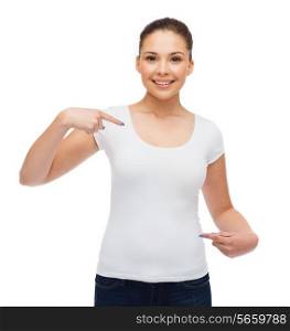 t-shirt design, people and gesture concept - smiling young woman in blank white t-shirt pointing fingers on herself
