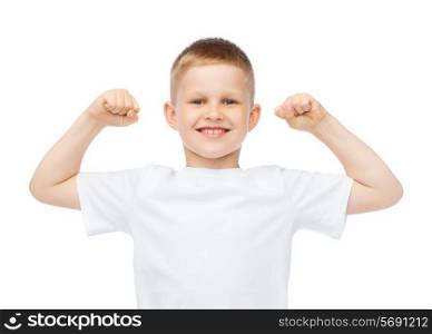 t-shirt design, strength, health, sport and fitness concept - little boy in blank white t-shirt showing muscles