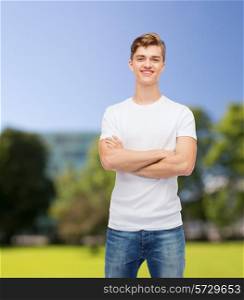 t-shirt design, summer, vacation and people concept - smiling young man in blank white t-shirt over park background
