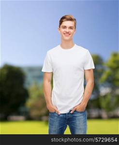 t-shirt design, summer, vacation and people concept - smiling young man in blank white t-shirt over park background
