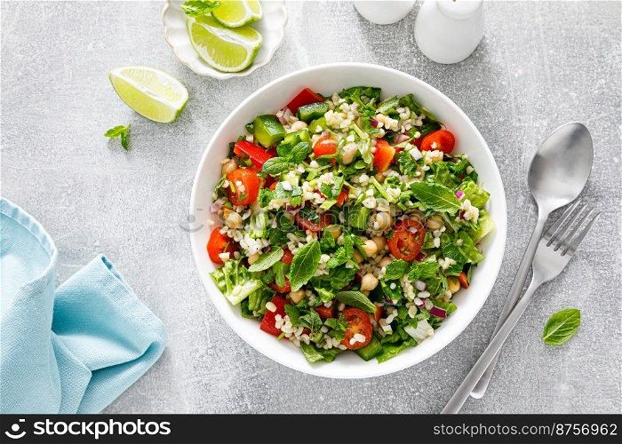 Tabbouleh salad. Tabouli salad with fresh parsley, onions, tomatoes, bulgur and chickpea. Healthy vegetarian food, mediterranean diet. Top view