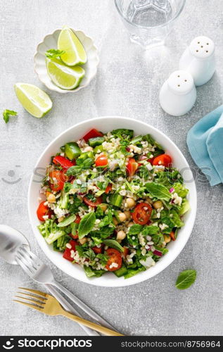 Tabbouleh salad. Tabouli salad with fresh parsley, onions, tomatoes, bulgur and chickpea. Healthy vegetarian food, mediterranean diet. Top view