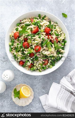 Tabbouleh salad. Tabouli salad with fresh parsley, onions, tomatoes, bulgur and green beans. Healthy vegetarian food, diet