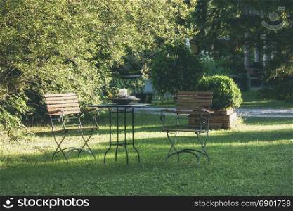 Table and chairs at summer green garden