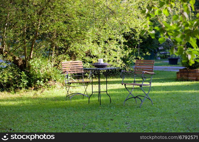 Table and chairs on a lawn at the garden