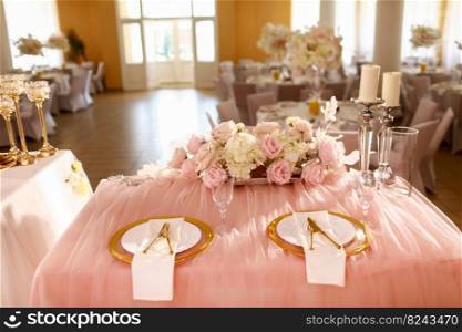 table decoration with pink tablecloth, crystal candlesticks with candles and white pink flowers in restaurant . stylish wedding day. setting table with gold plate, fork and knife.. table decoration with pink tablecloth, crystal candlesticks with candles and white pink flowers in restaurant . stylish wedding day. setting table with gold plate, fork and knife