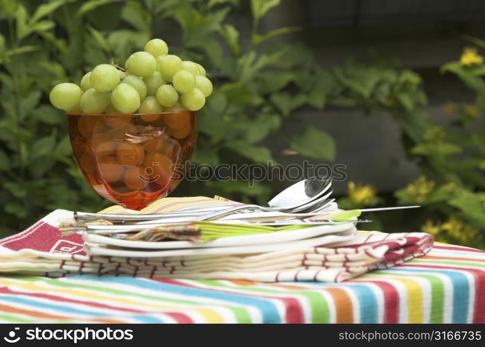 Table for two setout with a nice bowl of green grapes and plates ready