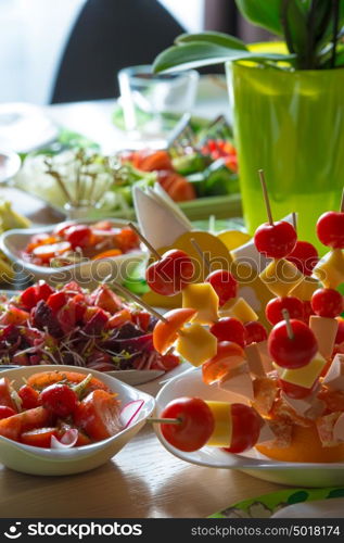 Table full of organic food - salads, cheese, tomatoes. Well decorated. Restaurant service and domestic food.