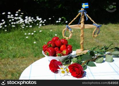 Table in a garden ready for swedish midsummer celebration