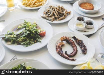 Table in greek restaurant. Salat and fish. Greece, Athens, Piraeus