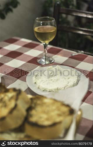 Table in restaurant in Greece. Red cover and glass of wine