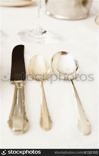 Table knife with two spoons on a dining table