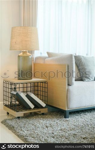 Table lamp on wooden table and light gray sofa in modern living room