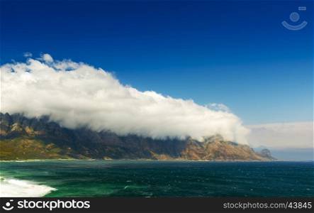 Table Mountain National Park coastline in South Africa with clouds over mountains