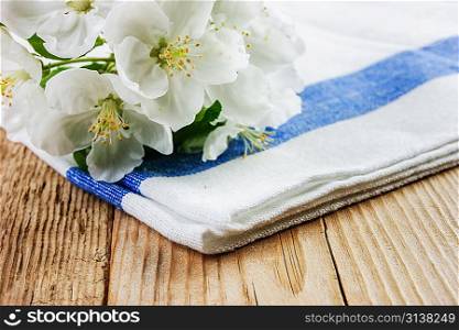 Table-napkin and bird cherry branch on a wooden background