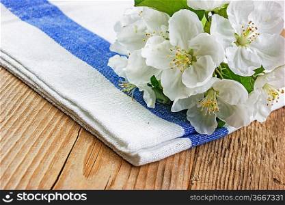 Table-napkin and bird cherry branch on a wooden background