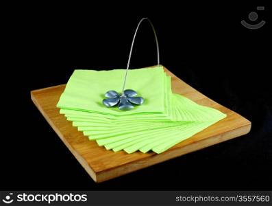 Table napkin holder on black background and green napkins