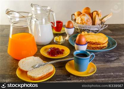 table of breakfast full set with eggs, pancakes, bread, jam ,juice and more