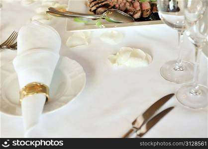 Table set for wedding reception with petal flowers on napkin