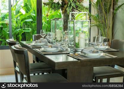 table set on wooden table and chairs in tropical dinning room