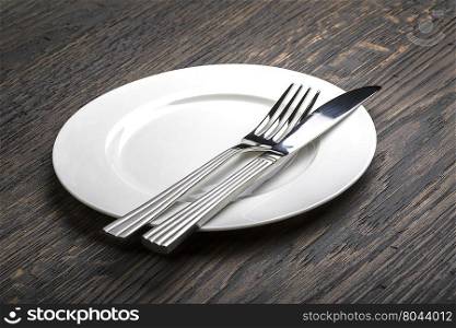 table setting. empty white plate with knife and fork