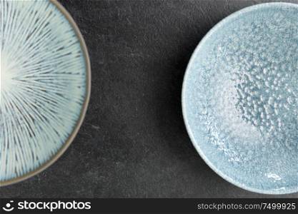 table setting, tableware and eating concept - close up of blue ceramic plate set on slate background. close up of blue ceramic plate on slate background
