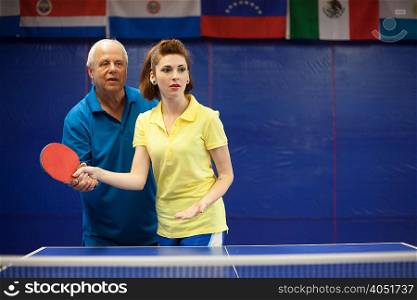 Table tennis coach teaching student to play