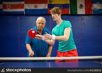 Table tennis coach watching student play