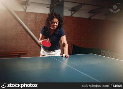 Table tennis, female player with racket and ball. Ping pong training indoor, high concentration sport game. Table tennis, female player with racket and ball