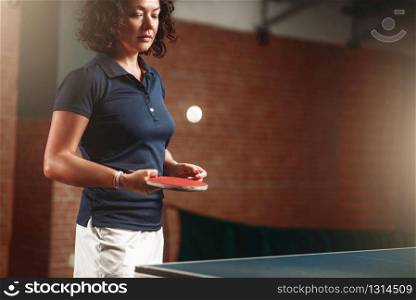 Table tennis, female player with racket hits ball. Ping pong training indoor, high concentration sport game. Table tennis, female player with racket hits ball