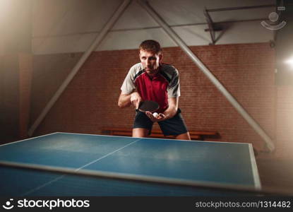 Table tennis, male player with racket and ball. Ping pong training indoor. Table tennis, male player with racket and ball