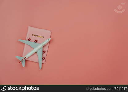 Table top view accessory of accessory travel in holiday background concept.Flat lay of airplane with passport for travel on modern rustic pink paper at home studio office desk.copy space for add text.