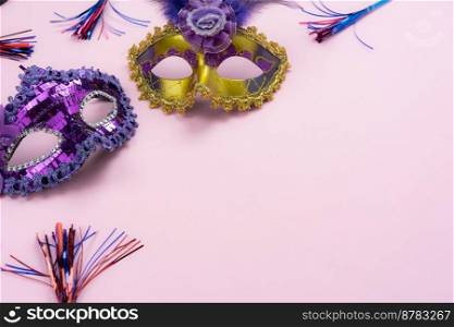 Table top view aerial image of beautiful colorful carnival festival background.Flat lay accessory object the several mask  decor confetti on modern pink paper at home office desk studio.copy space. 