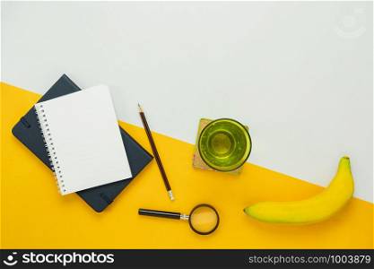 Table top view aerial image of count cal weight for sport fitness background concept.Flat lay essential objects paper clip & calculator with fresh water and banana on modern rustic white wooden.
