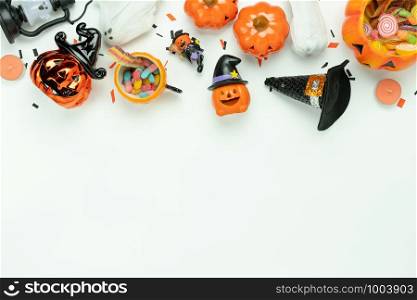 Table top view aerial image of decoration Happy Halloween day background concept.Flat lay accessories essential object to party the pumpkin & sweet candy on white wooden.Space for creative design.