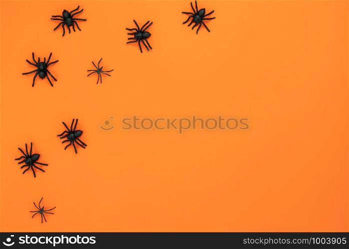 Table top view aerial image of decoration Happy Halloween day background concept.Flat lay accessories essential object to party the black spider on orange paper.Copy space for creative design mock up.
