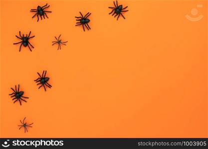 Table top view aerial image of decoration Happy Halloween day background concept.Flat lay accessories essential object to party the black spider on orange paper.Copy space for creative design mock up.