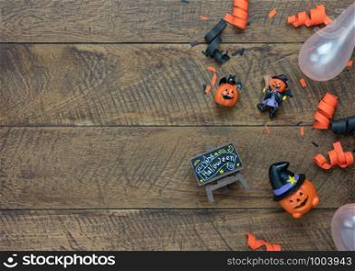 Table top view aerial image of decoration Happy Halloween day background concept.Flat lay accessories essential object to party the pumpkin doll & balloon on brown wooden.Space for creative design.