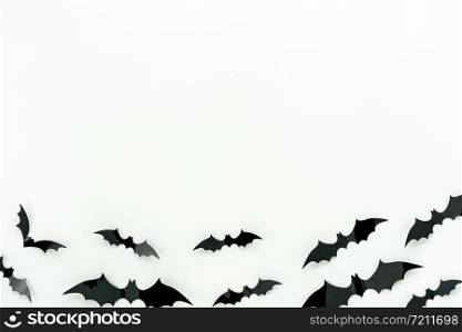 Table top view aerial image of decoration Happy Halloween day background concept.Flat lay accessories essential object to party the bat fly on white wooden wallpaper.Copy space for creative design.