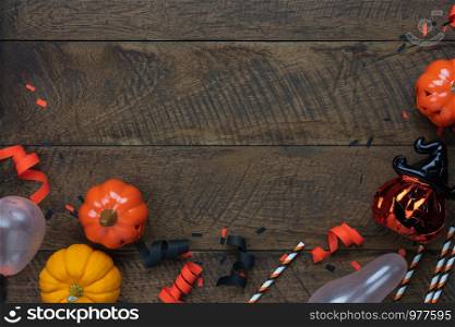 Table top view aerial image of decoration Happy Halloween day background concept.Flat lay accessories essential object to party the pumpkin & paper confetti on brown wooden.Space for creative design.