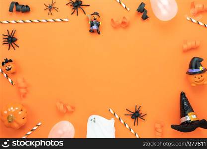 Table top view aerial image of decoration Happy Halloween day background concept.Flat lay accessories essential object to party the pumpkin & paper confetti on orange paper.Space for creative design.