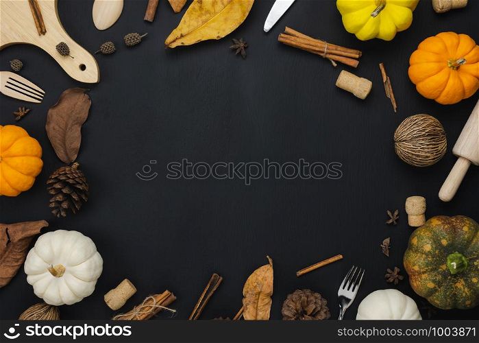 Table top view aerial image of decoration Happy Halloween or Thanksgiving day background concept.Flat lay variety object to party the pumpkin & dry leaf on black wooden.Space for creative design text.